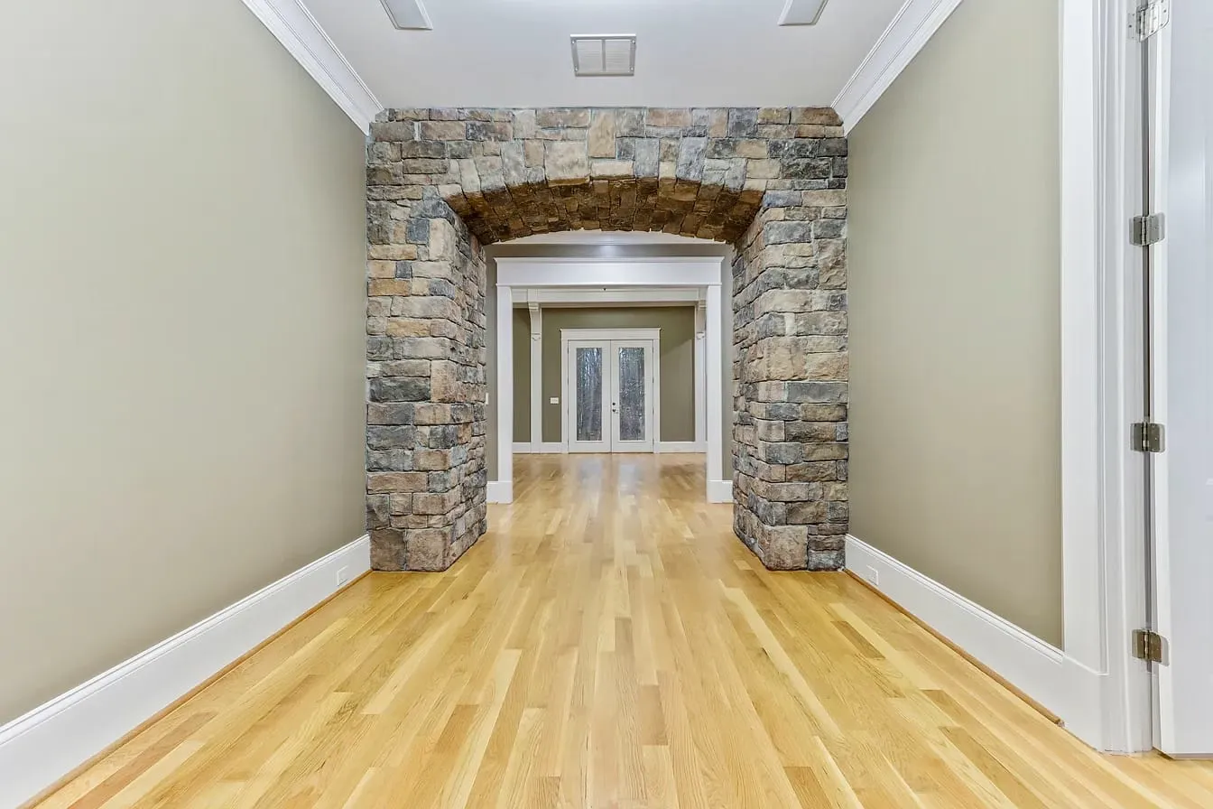 Stone arch hallway with hardwood floors